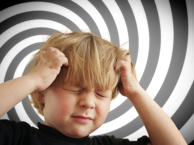 dete koje pati od vrtoglavice se drži za glavu, u pozadini prikaz vrtoglavice