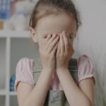 devojčica se drži rukama za glavu