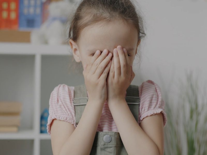 devojčica se drži rukama za glavu