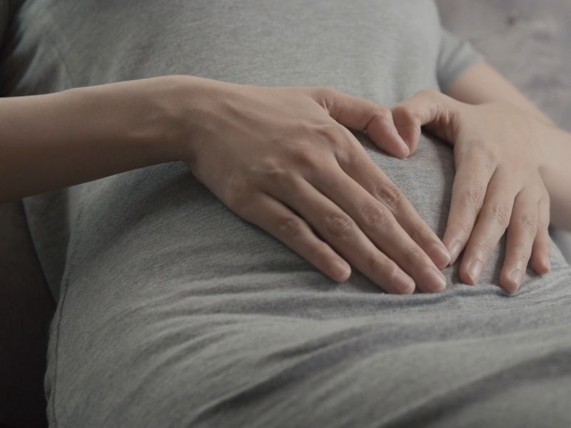 majka pravi srce od ruku i stavlja na stomak u kom je beba